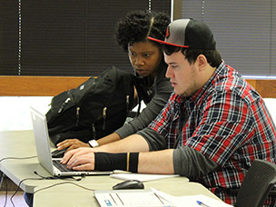Pair of students collaborating on a laptop