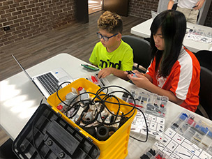 Two middle schoolers building an electronic device